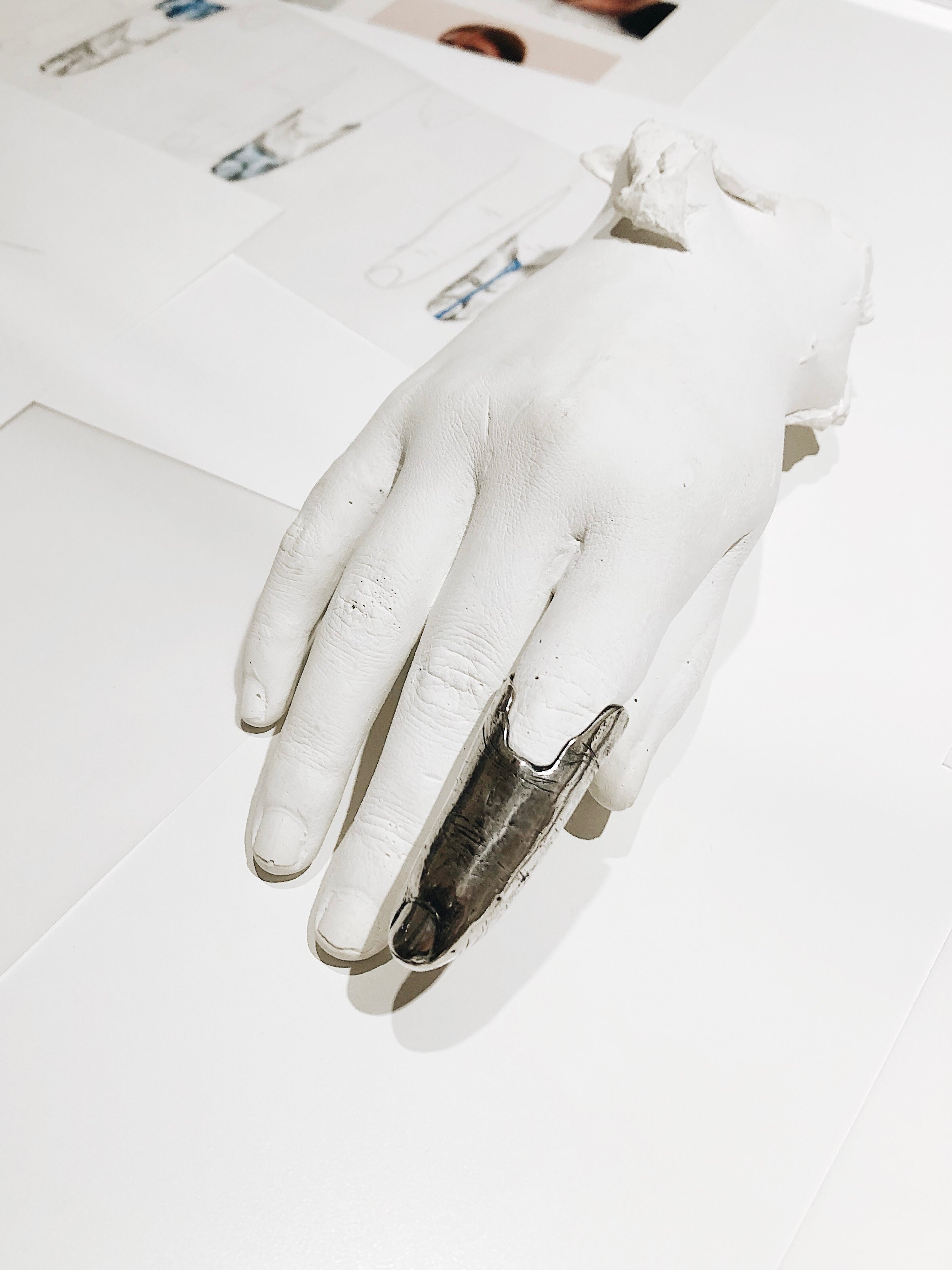 FINGER ACCESSORY IN SILVER DISPLAYED IN PLASTER HAND